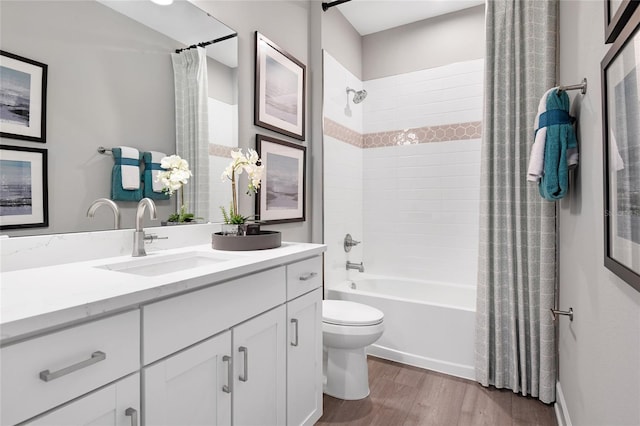 full bathroom with hardwood / wood-style floors, toilet, shower / tub combo, and vanity