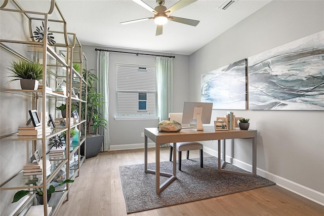 office space featuring baseboards, wood finished floors, visible vents, and ceiling fan