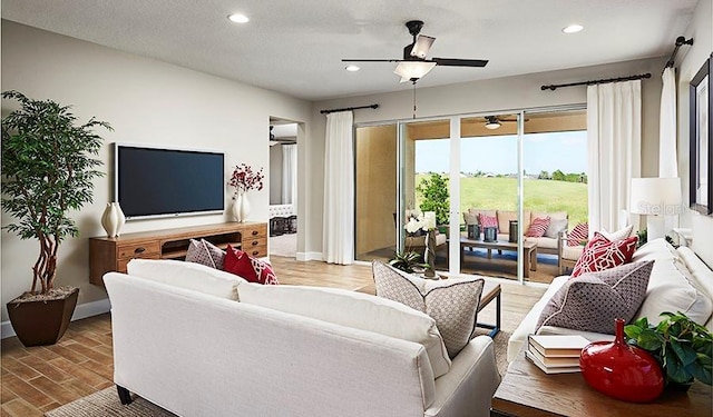 living room with a textured ceiling, ceiling fan, and hardwood / wood-style flooring