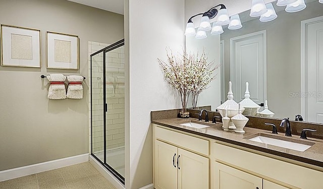 bathroom featuring a shower with shower door, vanity, and tile patterned floors