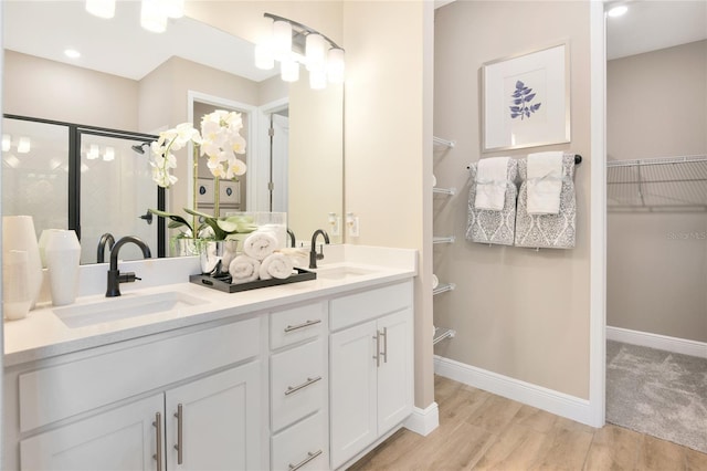 bathroom featuring a shower with shower door, wood-type flooring, and vanity