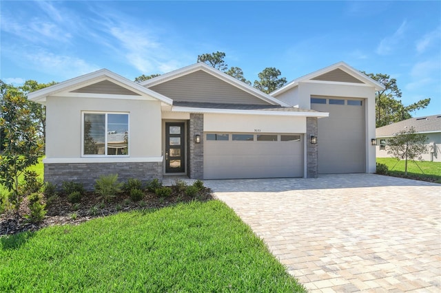 9093 Players Dr, Weeki Wachee, FL 34613 - view of front of house featuring an attached garage, decorative driveway, stone siding, and a front yard