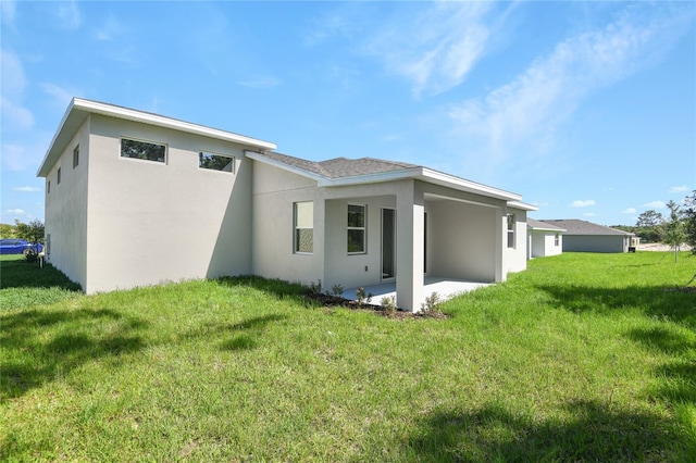 9093 Players Dr, Weeki Wachee, FL 34613 - back of property featuring a patio, stucco siding, and a lawn