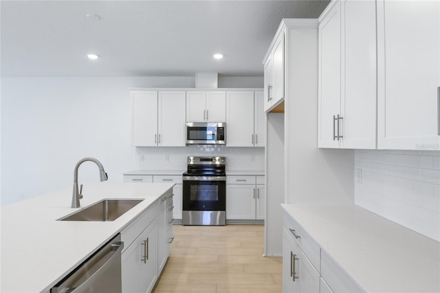 9093 Players Dr, Weeki Wachee, FL 34613 - kitchen with appliances with stainless steel finishes, a sink, light countertops, tasteful backsplash, and light wood-style floors