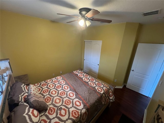 bedroom with ceiling fan, wood-type flooring, and a closet