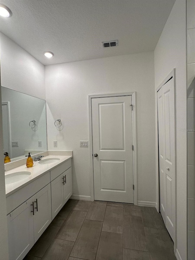 bathroom with a textured ceiling and vanity