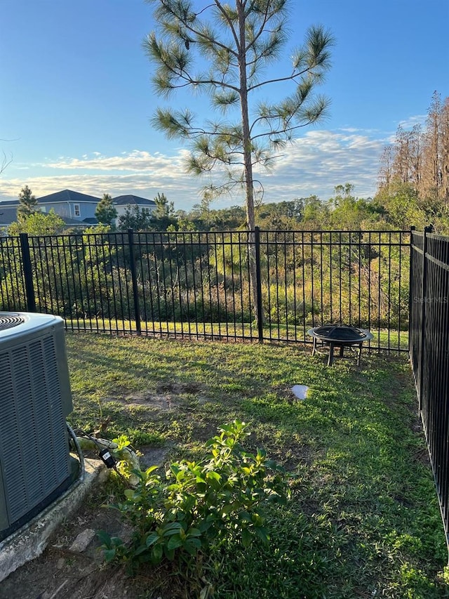 view of yard featuring an outdoor fire pit and central AC