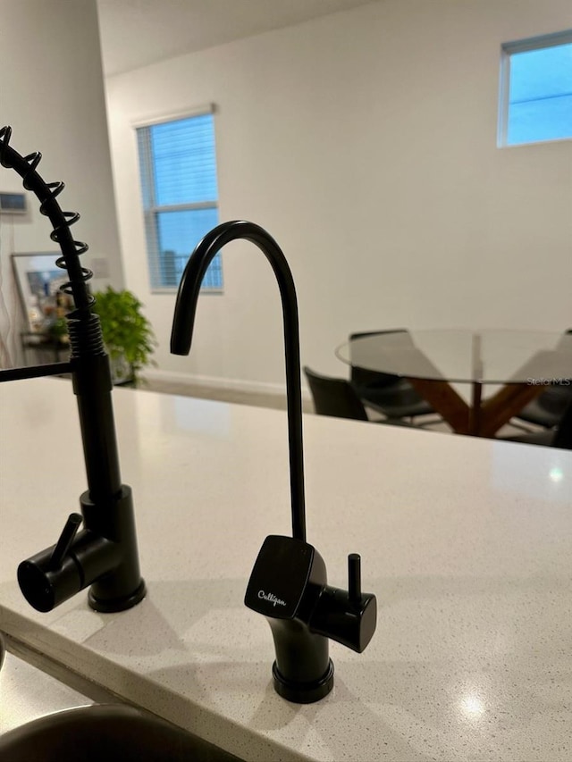 room details featuring light stone countertops and sink