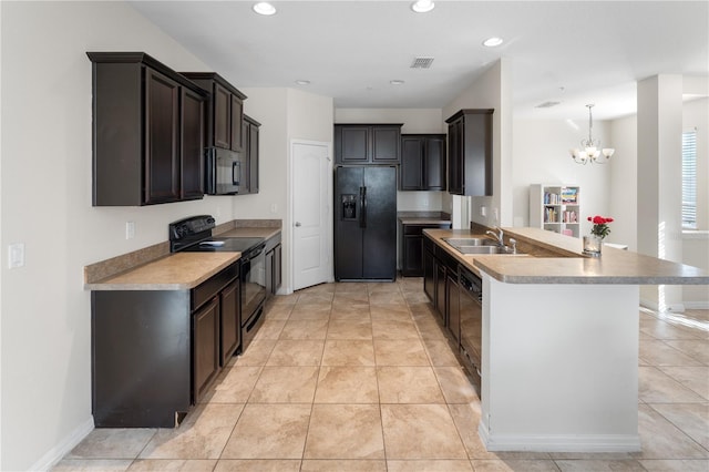 kitchen featuring black appliances, sink, hanging light fixtures, a chandelier, and light tile patterned floors