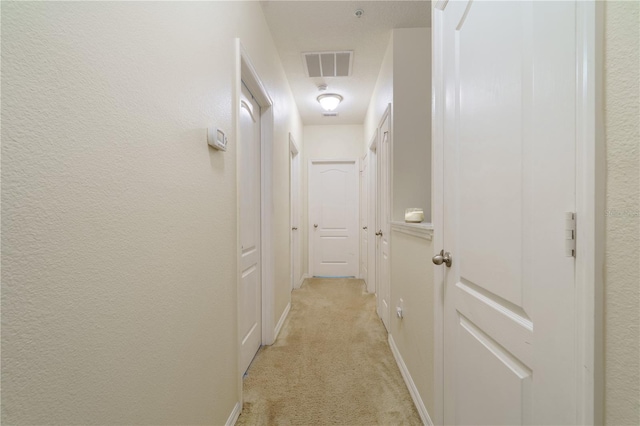 hall with light colored carpet