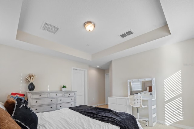 bedroom featuring light carpet and a raised ceiling