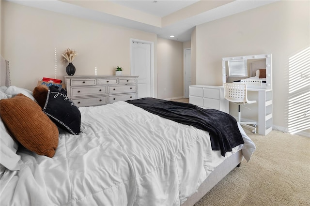 bedroom featuring light carpet and a raised ceiling