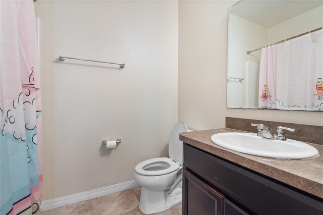 bathroom with toilet, vanity, tile patterned flooring, and walk in shower