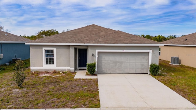 ranch-style home with a front yard, a garage, and central AC unit