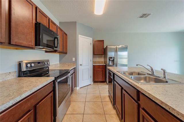 kitchen featuring a textured ceiling, light tile patterned floors, sink, and black appliances