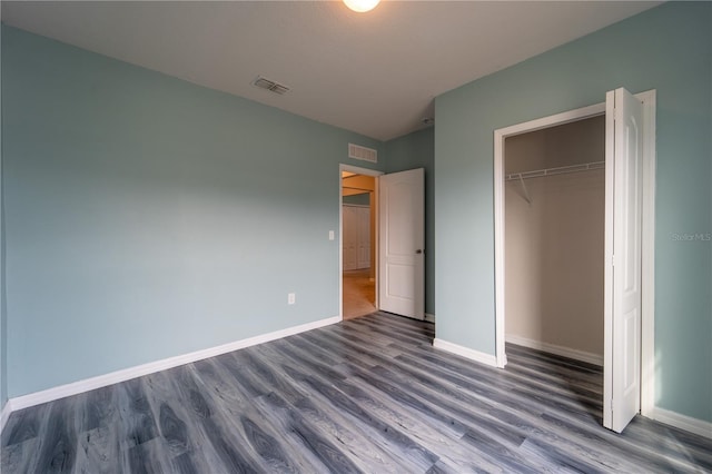 unfurnished bedroom featuring a closet and dark hardwood / wood-style flooring