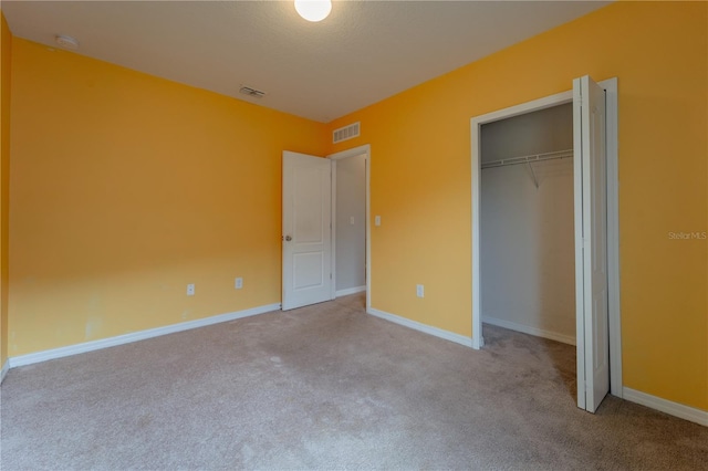 unfurnished bedroom featuring light carpet and a closet