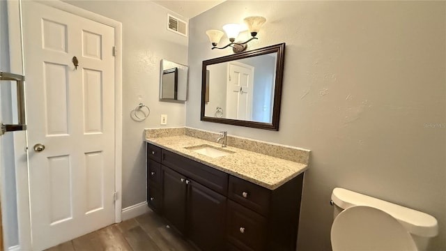 bathroom with toilet, wood-type flooring, and vanity