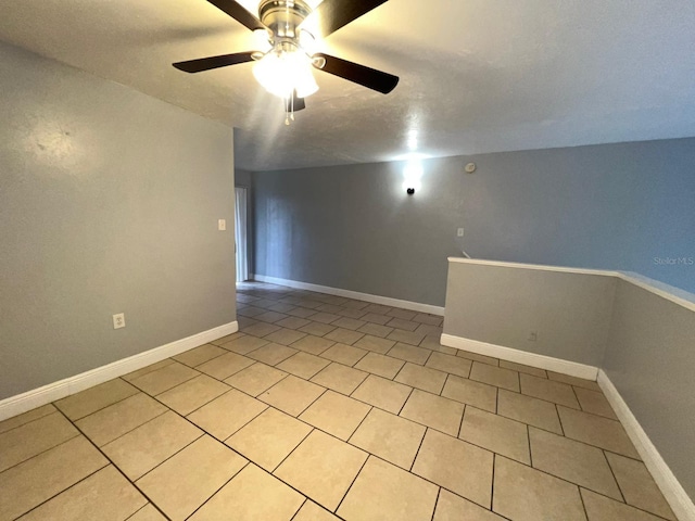 tiled empty room featuring ceiling fan