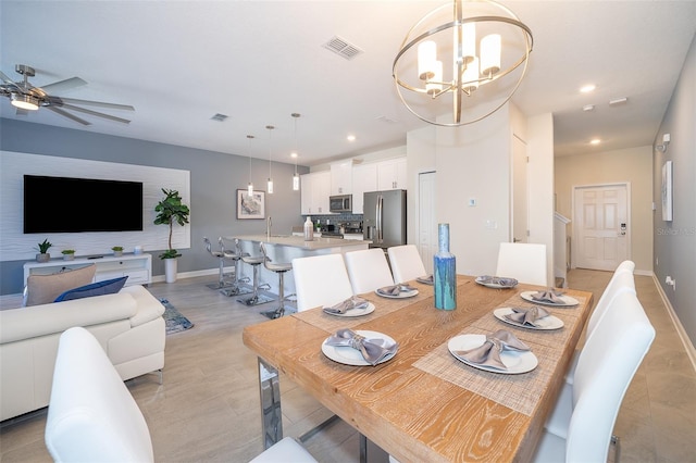 dining area with ceiling fan with notable chandelier