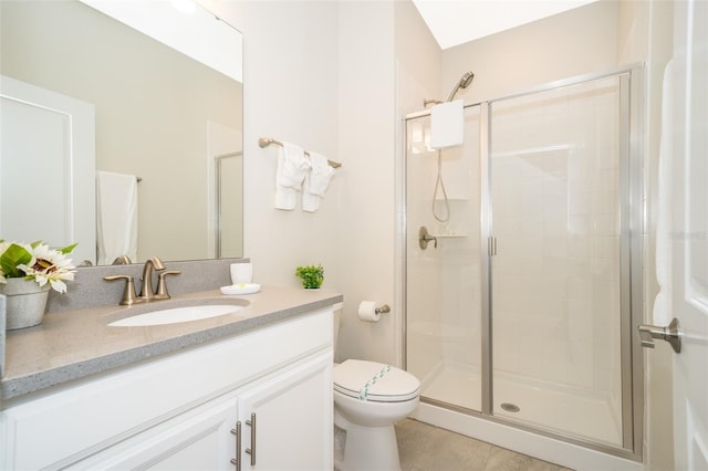 bathroom with tile patterned floors, a shower with door, toilet, and vanity