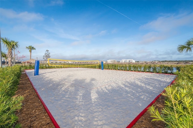 surrounding community with volleyball court and a water view