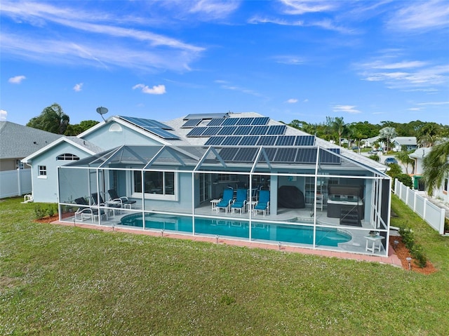 back of property featuring a patio area, a lanai, a lawn, and solar panels