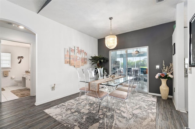 dining room featuring a textured ceiling, dark hardwood / wood-style floors, and a notable chandelier