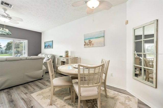 dining space featuring a textured ceiling and light hardwood / wood-style flooring