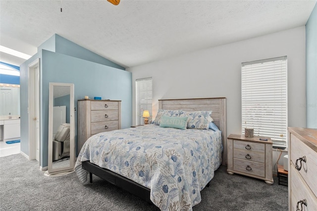 carpeted bedroom with ensuite bath, vaulted ceiling, a textured ceiling, and ceiling fan