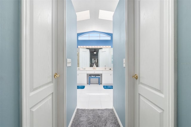 corridor featuring light carpet and lofted ceiling