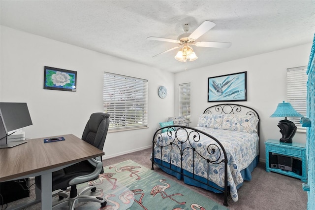 carpeted bedroom with ceiling fan and a textured ceiling