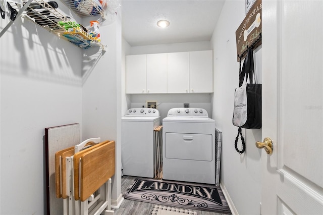 washroom featuring washing machine and dryer, cabinets, and hardwood / wood-style flooring