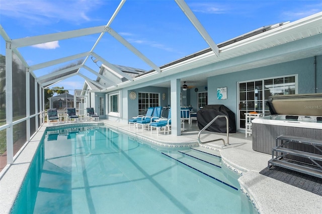 view of pool with ceiling fan, a jacuzzi, a patio area, a grill, and a lanai