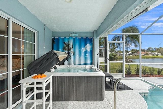 sunroom featuring a water view and a hot tub