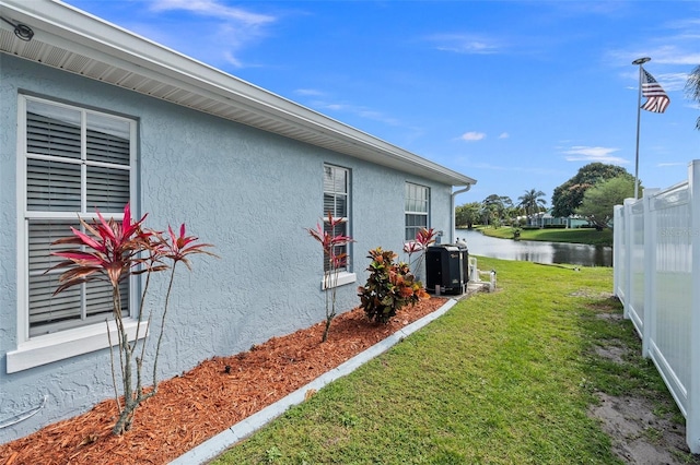 view of home's exterior featuring a water view and a lawn