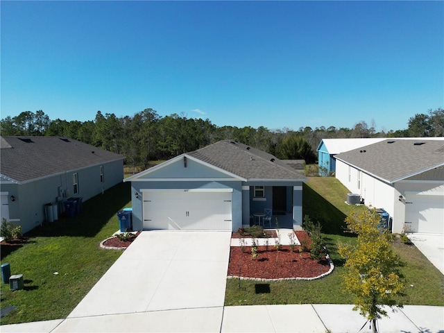 view of front of home with cooling unit, a garage, and a front lawn