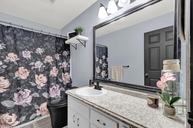 bathroom featuring vaulted ceiling, hardwood / wood-style floors, a textured ceiling, toilet, and vanity