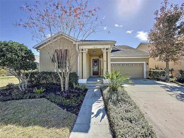 view of front of house featuring a garage, driveway, a shingled roof, and stucco siding