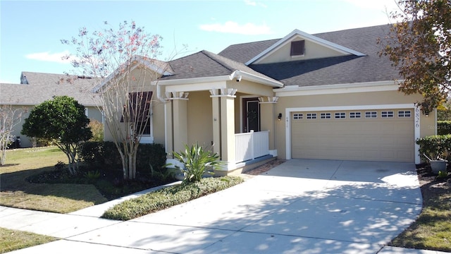 view of front of home with a shingled roof, driveway, an attached garage, and stucco siding