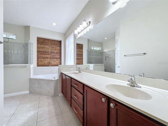 bathroom with tile patterned flooring, a sink, a bath, and a shower stall