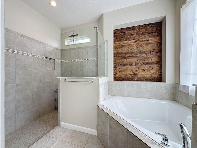 bathroom with a garden tub, a walk in shower, a textured ceiling, and tile patterned floors