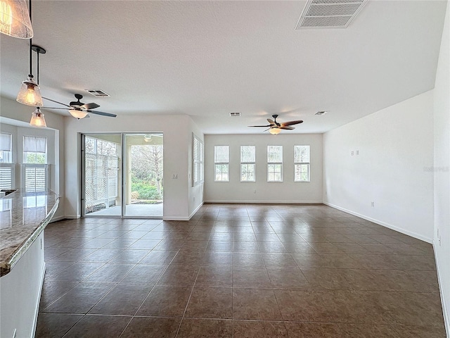 unfurnished room featuring baseboards, visible vents, and a ceiling fan