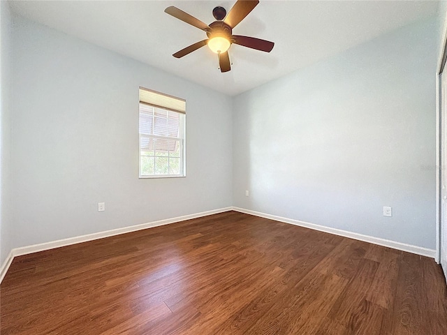 spare room featuring dark wood finished floors and baseboards