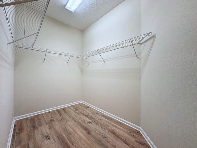 walk in closet with wood finished floors