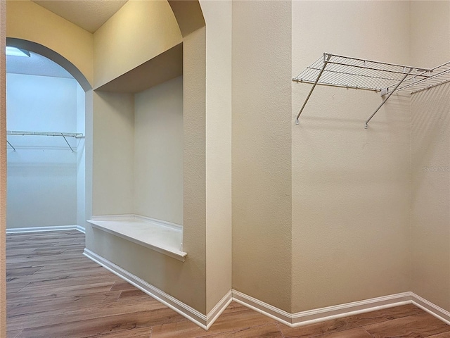 interior space featuring arched walkways and wood finished floors