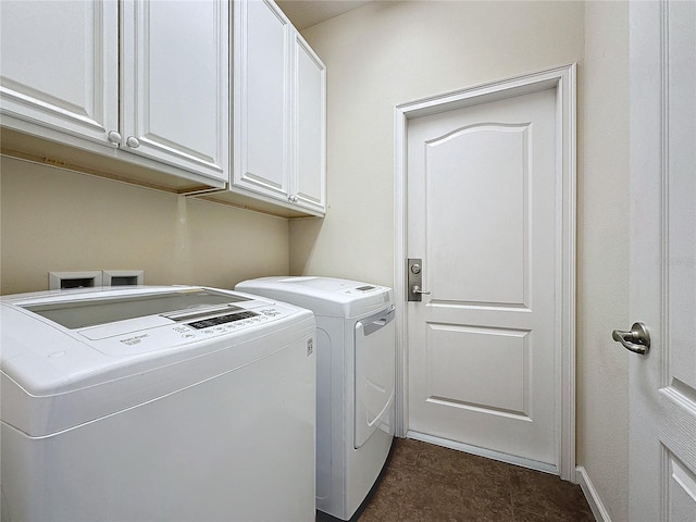 clothes washing area featuring washer and dryer, cabinet space, and baseboards