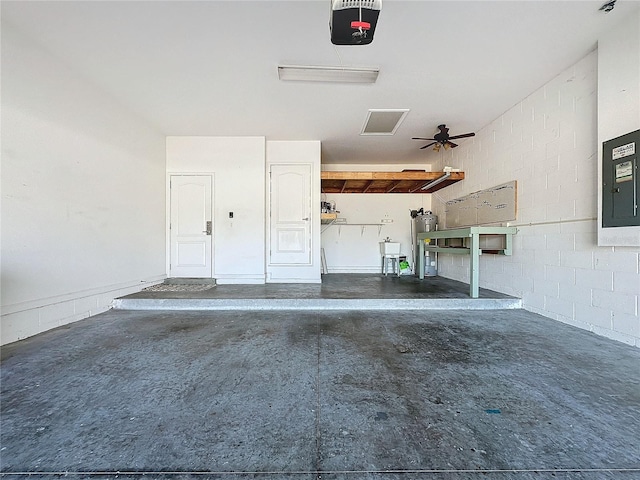 garage with a garage door opener, concrete block wall, and electric water heater