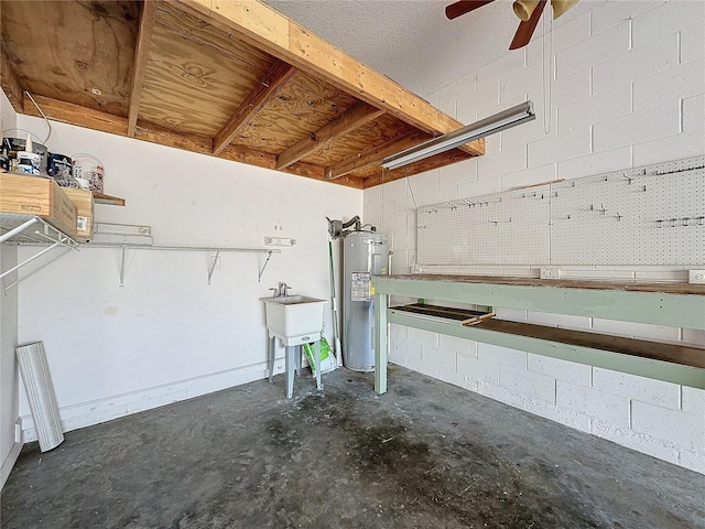 garage with water heater, a workshop area, a sink, and concrete block wall