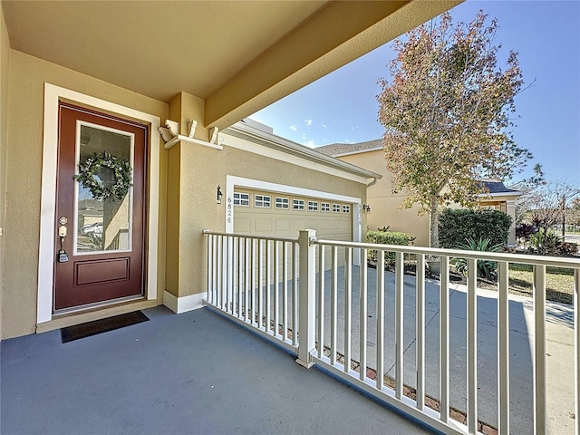 entrance to property with a garage and stucco siding